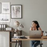 woman in black tank top using macbook